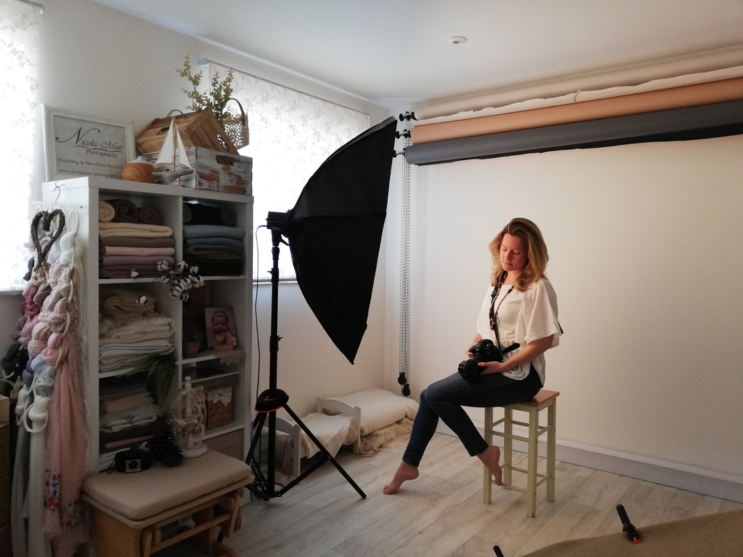 nicola muir photography studio in gosport hampshire self portrait sitting on chair in studio with camera